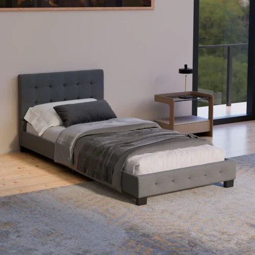 Pat modern tapițat gri într-un dormitor minimalist